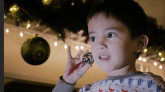 Young boy ringing a Christmas bell during Magical Train Ride film_DreamPlay TV