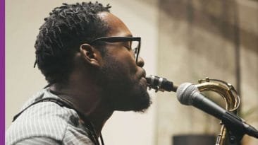 Close up of Josue Simon playing saxophone on Brick City Blues, Winner and Peer Pressure