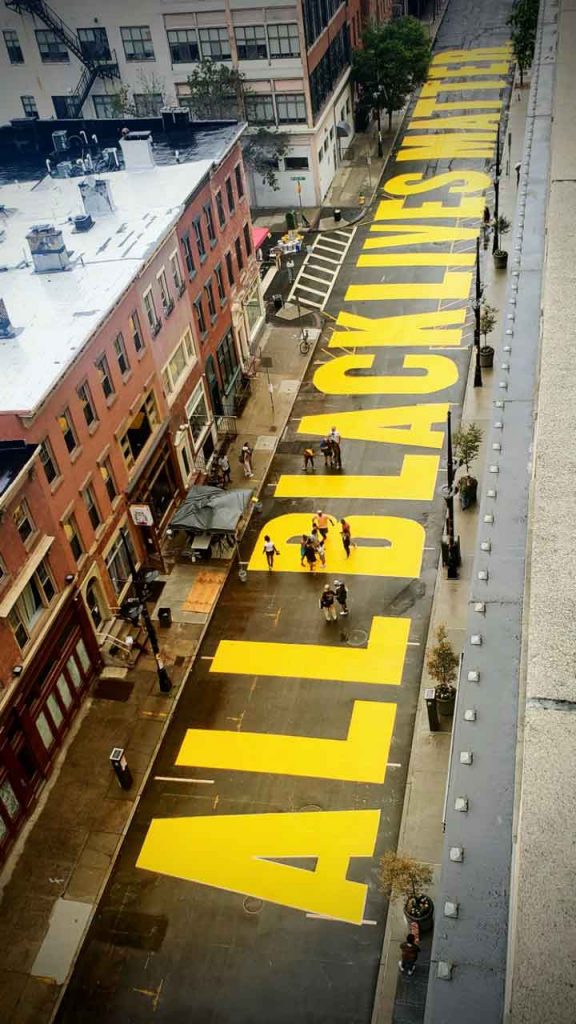 All Black Lives Matter street mural completed in rainy weather.
